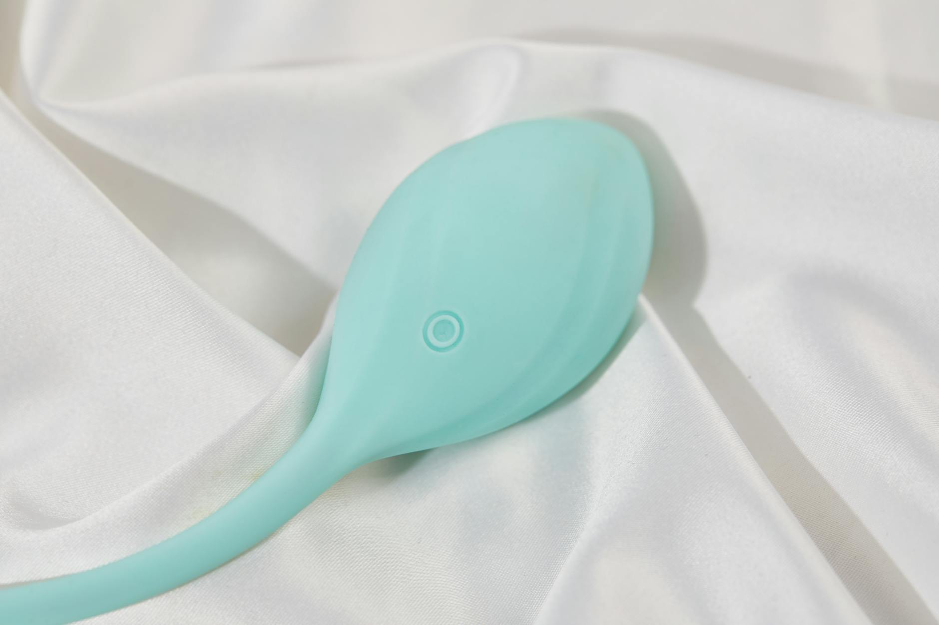 A sleek lemon vibrator on white silk fabric, elegant and approachable